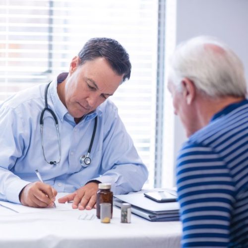 Doctor prescribing medicine to senior patient in clinic